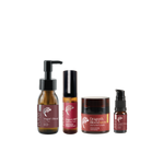 Four amber glass cosmetic bottles and jars with black caps arranged on a plain white background. The labels read Dragon's Blood, including Hair Oil, Hair Growth Serum, Intensive Lip Balm, and a smaller serum bottle.