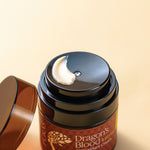Jar of 'Dragon's Blood' antioxidant cream with a visible brand logo on a beige background