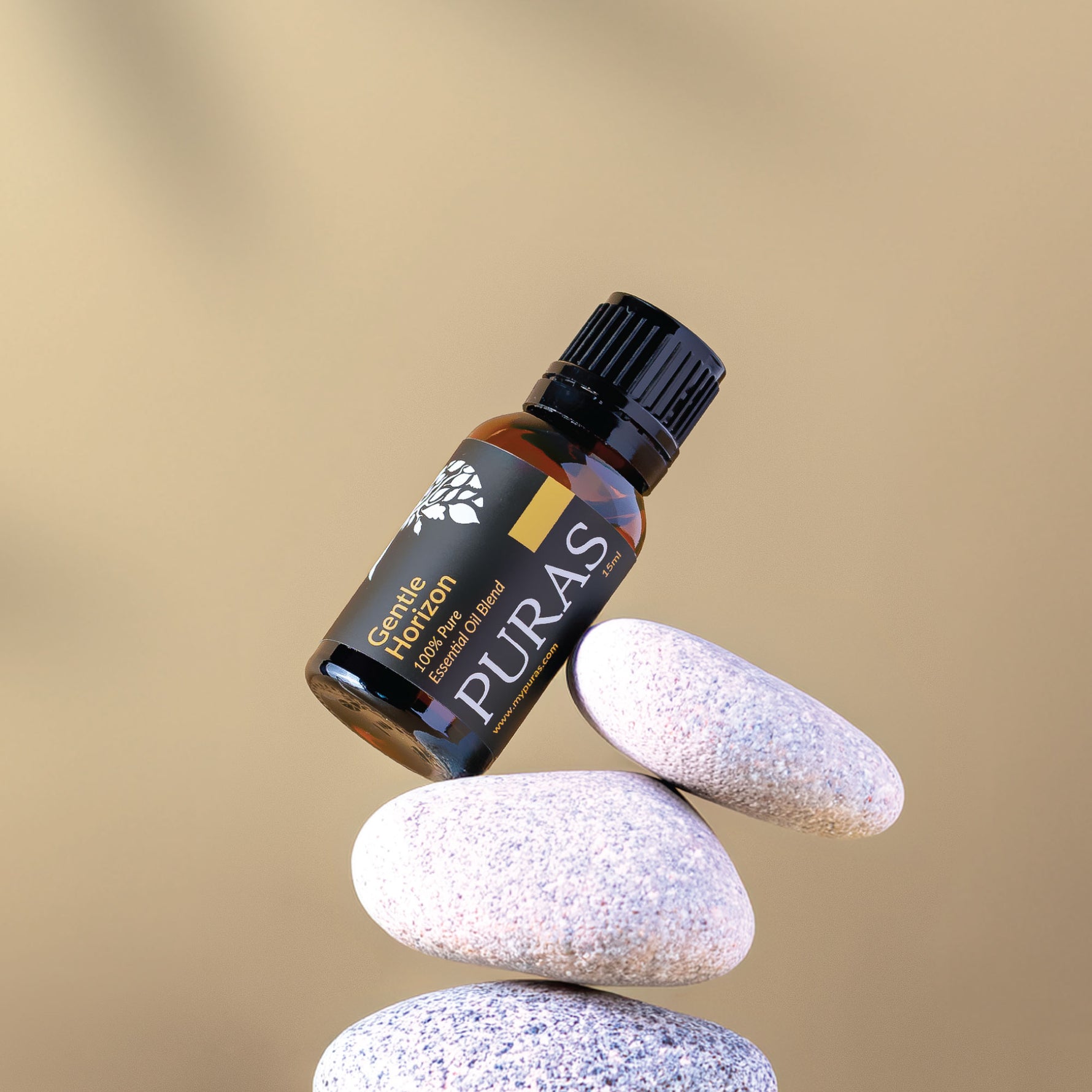 Puras essential oil bottle balanced on stones with a beige background