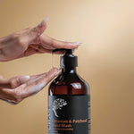 Hand holding a pump of Puras Geranium & Patchouli Hand Wash against a beige background