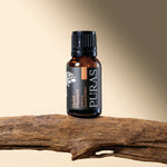 Puras "Quiet Moment" essential oil bottle on a wooden branch with a gradient beige background