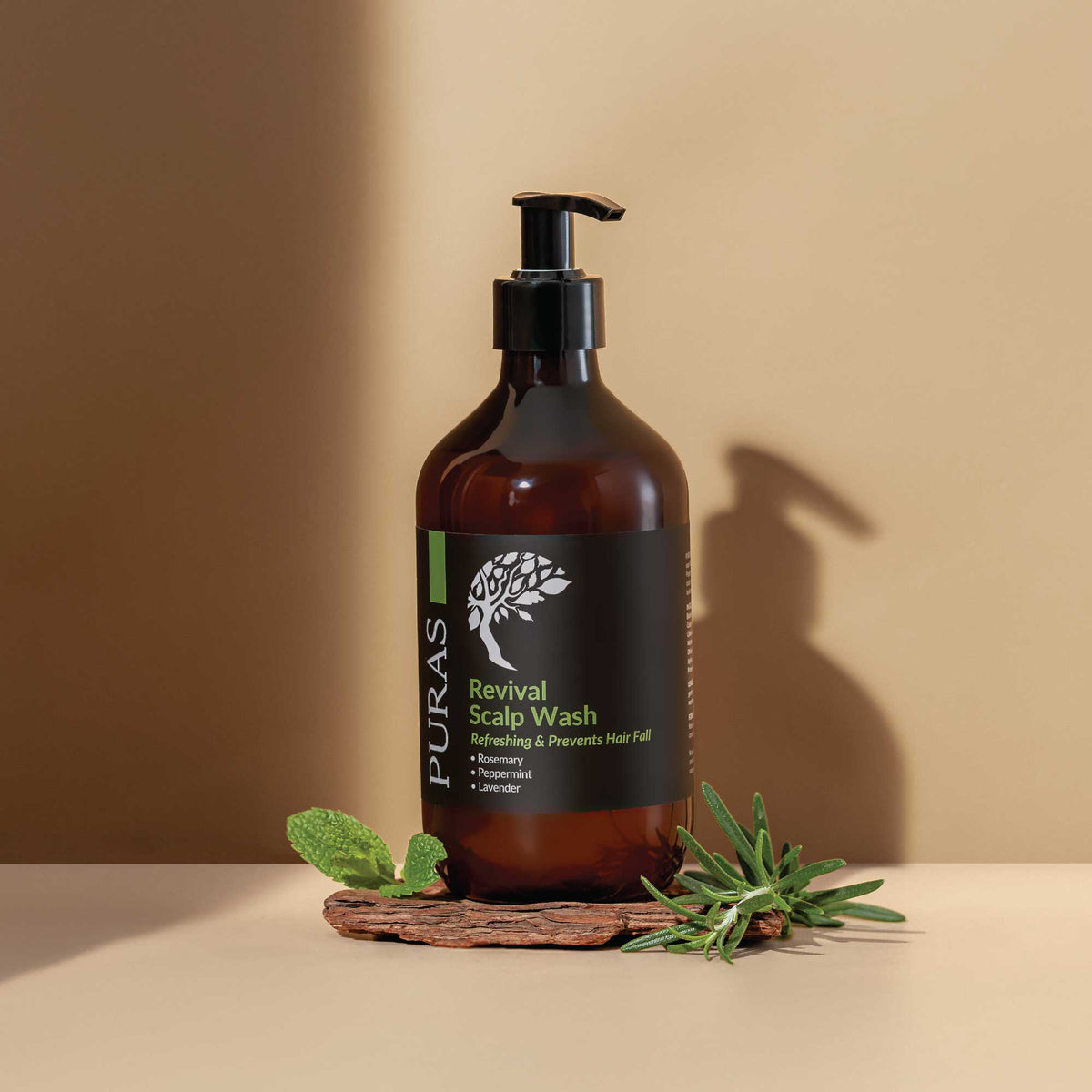 Brown bottle of Puras Revival Scalp Wash with a peppermint leaf on a beige background