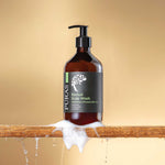 Brown bottle of PURAS Revival Scalp Wash with a pump on a wooden base against a beige background