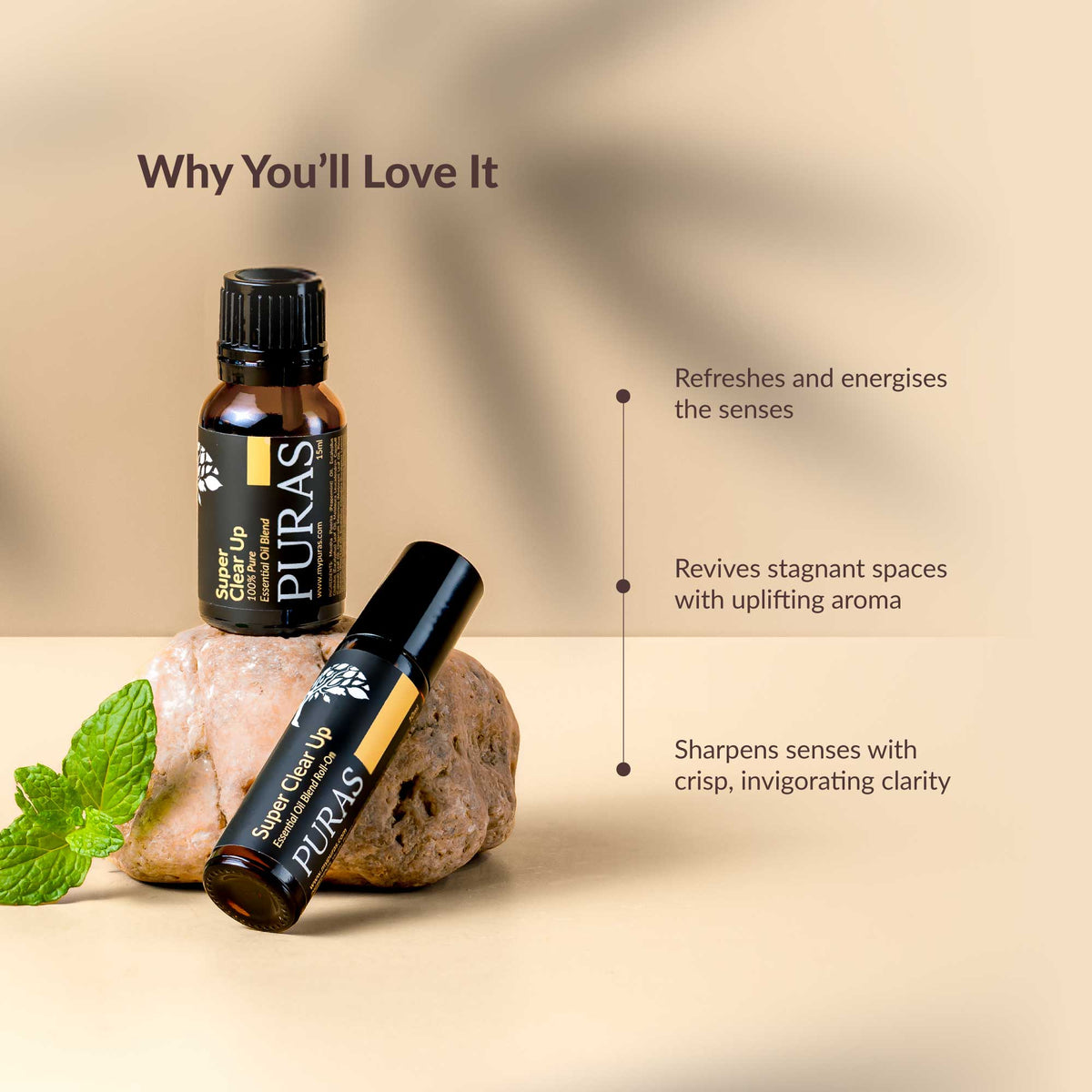 Two bottles of PURAS essential oils with a rock and mint leaves on a beige background.